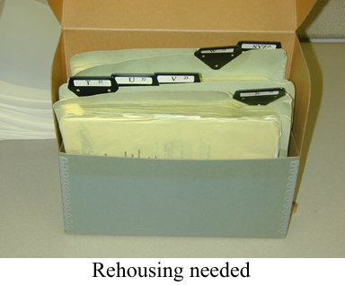 Folders of papers in box with caption "Rehousing needed".